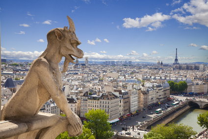 Notre Dame of Paris: Famous Chimera (demon) overlooking the Eiffel Tower at a summer day